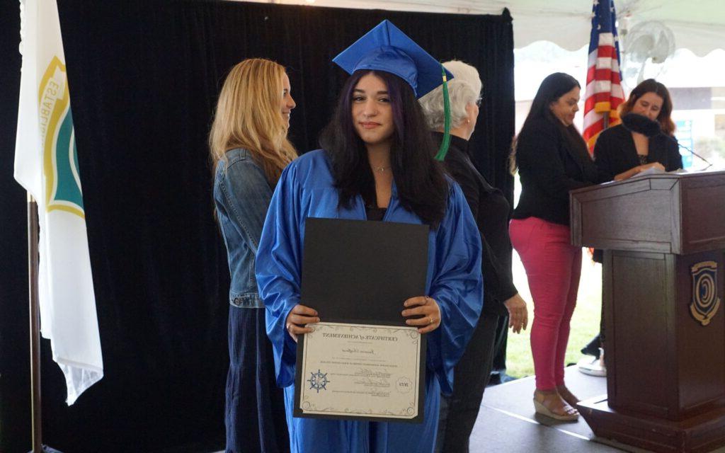 Woman holding her diploma certificate at graduation